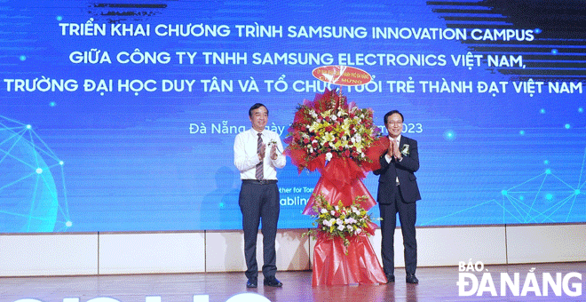 Chairman of the Da Nang People's Committee Le Trung Chinh (left) presents flowers to Mr. Choi Joo Ho, General Director of Samsung Vietnam at the signing ceremony. Photo: NGOC HA