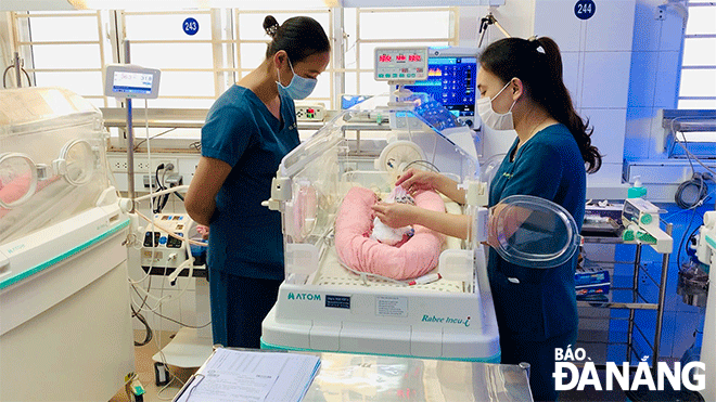 Ths, bác sĩ Huỳnh Thị Lệ, Trưởng khoa Nhi sơ sinh Cấp cứu - Hồi sức tích cực và Bệnh lý, Bệnh viện Phụ Sản - Nhi Đà Nẵng (bên trái) đang quan sát theo dõi tình hình một bệnh nhi sơ sinh. Ảnh: TV