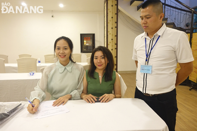 Đại diện Công ty TNHH Xây dựng phát triển Thái Anh Đà Nẵng phấn khởi ký biên bản sau khi trúng đấu giá. Ảnh: HOÀNG HIỆP