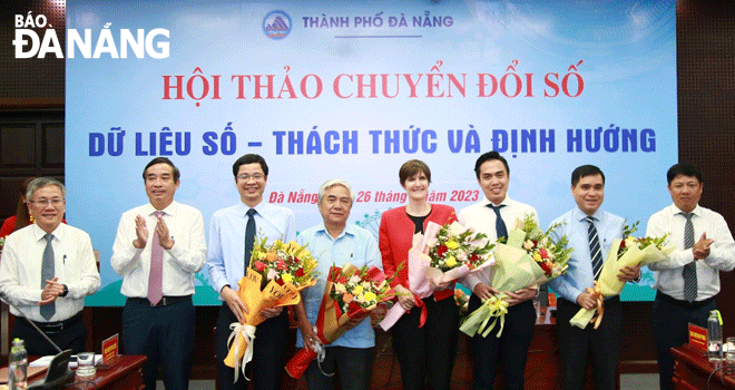 Phó Bí thư Thường trực Thành ủy Lương Nguyễn Minh Triết (bìa phải) và Chủ tịch UBND thành phố Lê Trung Chinh (thứ 2, trái sang) tặng hoa cho các chuyên gia, đại biểu tham dự hội thảo. Ảnh: M.Q - C.T