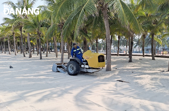 Công nhân Xí nghiệp Môi trường sông biển đang sàng cát tại bãi biển Phạm Văn Đồng, bảo đảm bãi cát luôn sạch, mịn. Ảnh: N.H