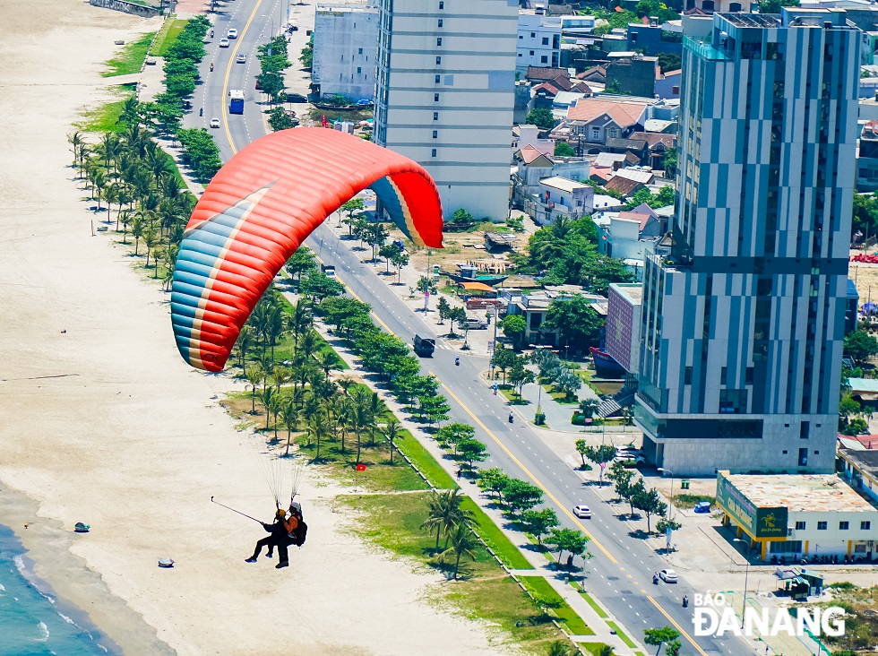 Paragliders fly above local beaches