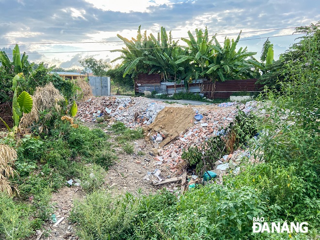 Một đoạn con mương bị lấp đất khiến dòng chảy thay đổi hướng tràn vào nhà dân khi có mưa.