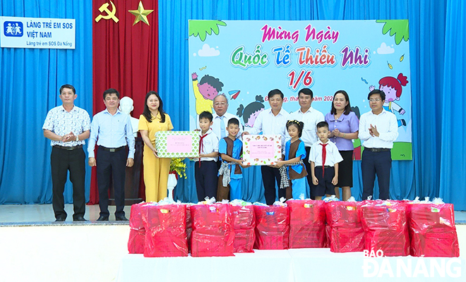 Phó Bí thư Thường trực Thành ủy Lương Nguyễn Minh Triết (thứ 4, bên phải sang) tặng quà cho các em ở Làng trẻ em SOS Đà Nẵng. Ảnh: X.D