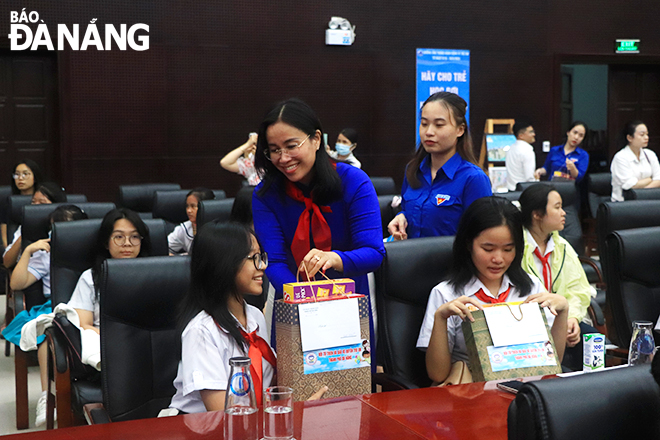 Vice Chairwoman of the municipal People's Council Nguyen Thi Anh Thi presenting gifts to children participating in the dialogue forum. Photo: X.D