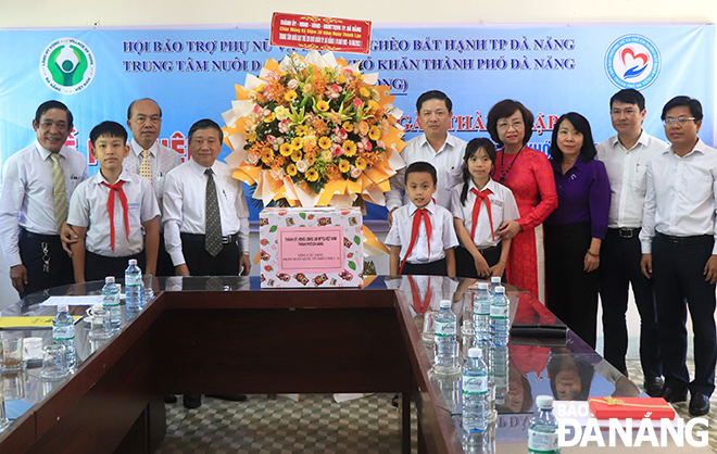 Da Nang Party Committee Deputy Secretary cum People’s Council Chairman Luong Nguyen Minh Triet (5th, right) and municipal People's Committee Vice Chairwoman Ngo Thi Kim Yen (4th, right) visited and gave gifts to children being cared for at the Village of Hope in Thanh Khe District. Photo: X.D