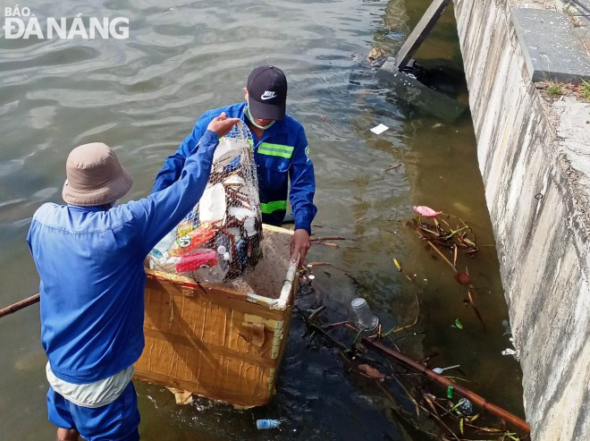 Các công nhân Công ty CP Môi trường đô thị Đà Nẵng thu gom các loại rác thải nhựa phát sinh trên sông Hàn vào sáng 3-6 sau đêm pháo hoa. Ảnh: HOÀNG HIỆP