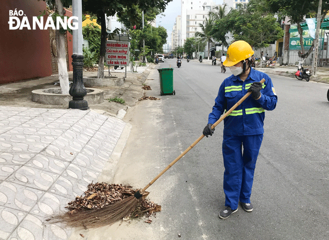 Bà Đặng Thị Điệp, công nhân Xí nghiệp Môi trường quận Sơn Trà đang quét dọn tại tuyến đường Trần Bạch Đằng và Nguyễn Văn Thoại (đoạn thuộc quận Sơn Trà). Ảnh: M.Q