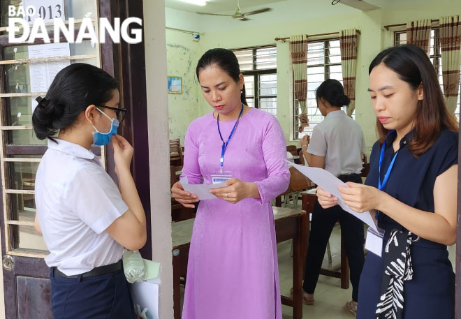 An exam invigilator checks the attendance of candidates before allowing them to enter the exam room 