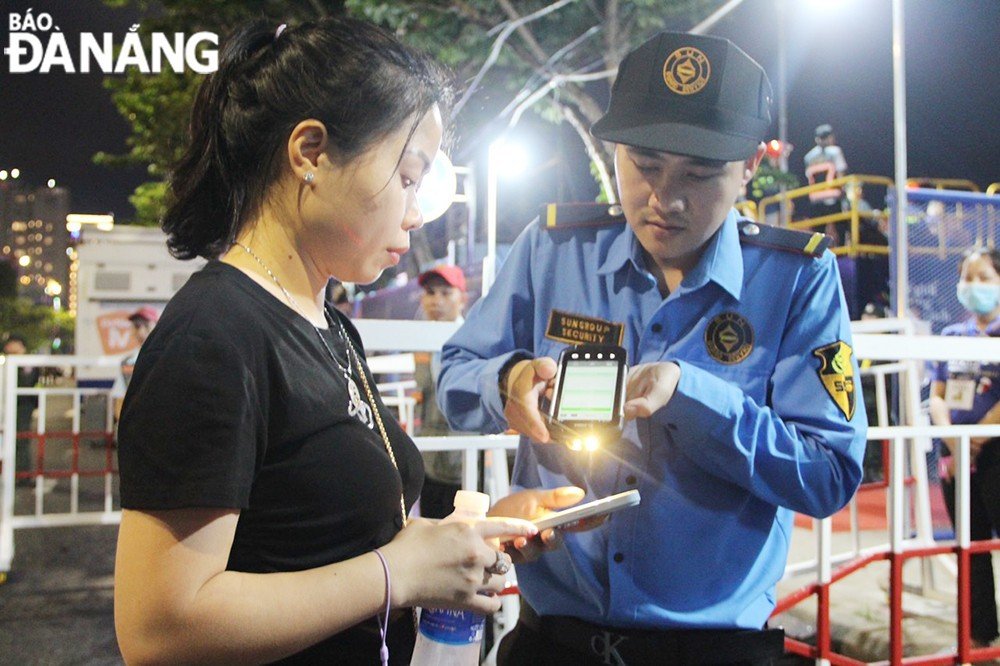 A security guard checks tickets at the entrance to viewing stands.