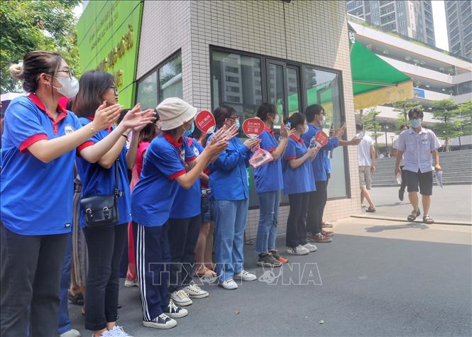 Tình nguyện viên cổ vũ thí sinh hoàn thành môn Ngữ Văn tại điểm thi trường THCS Trần Duy Hưng (quận Cầu Giấy). Ảnh: Tuấn Đức/TTXVN