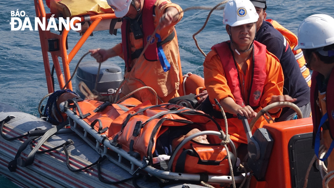 Mr. Tran Van Khoi (right) and his teammates save a fishing boat in distress at sea