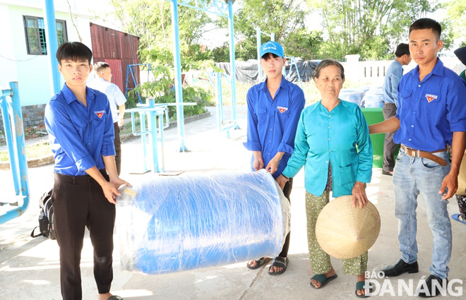 Hộ gia đình khó khăn được cấp phát một thùng nhựa không thấm nước để chứa các đồ dùng có giá trị, giấy tờ tùy thân, lương thực, thực phẩm. Ảnh: HOÀNG HIỆP