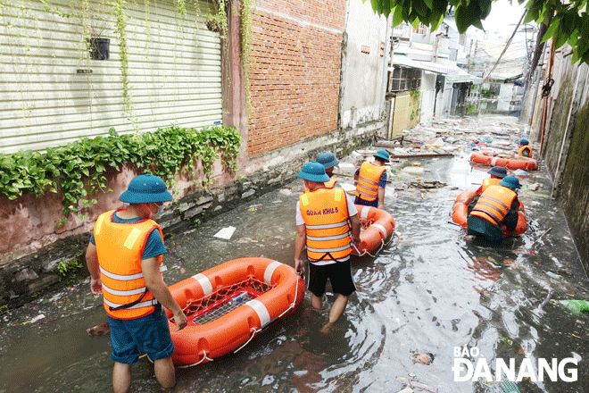 Lực lượng xung kích phường Chính Gián, quận Thanh Khê di chuyển vào hỗ trợ người dân ở khu vực kiệt của đường Thái Thị Bôi bị ngập sâu vào chiều 15-10-2022. Ảnh: H.H