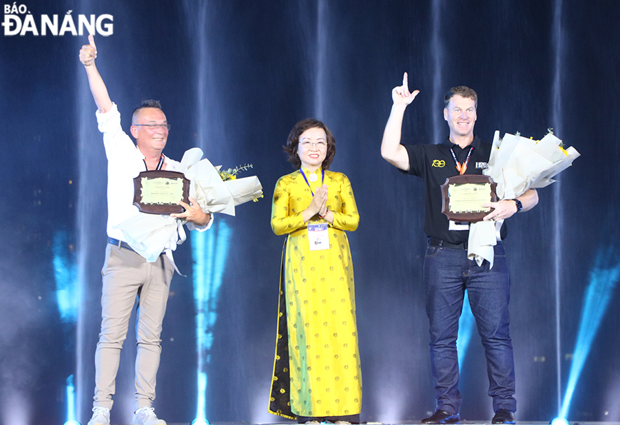 Vice Chairwoman of the Da Nang People's Committee Ngo Thi Kim Yen (middle) presents souvenirs to the Italian and Australian teams attending the third performance night, June 17, 2023.