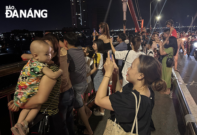 A small family posing for photos with fireworks