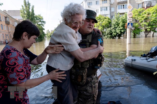 Sơ tán người dân khỏi các khu vực ngập lụt ở Kherson, Ukraine, sau sự cố vỡ đập thủy điện Kakhovka. (Ảnh: AFP/TTXVN)