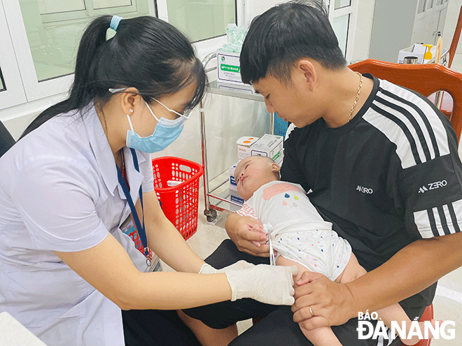 Phụ huynh đưa con tiêm vắc-xin phòng bệnh tại CDC Đà Nẵng. Ảnh: T.V