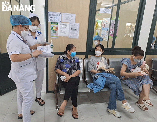Cán bộ Trung tâmY tế quận Thanh Khê hướng dẫn khám, chữa bệnh cho người dân. Ảnh: KHÁNH HÒA