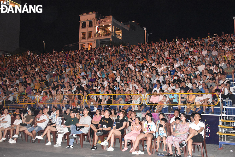 Thousands of spectators in viewing stands attentively enjoy the performance 