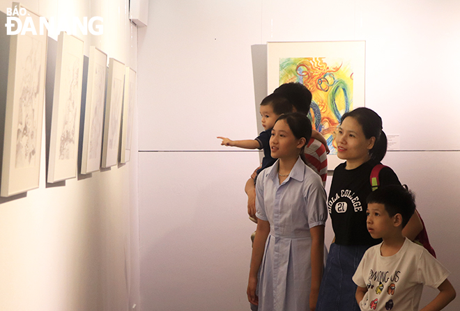 A family visited the exhibition on the afternoon of June 24. Photo: X.D