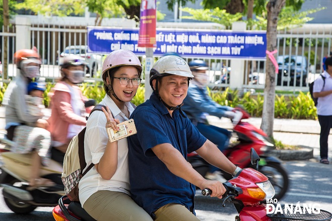 Phụ huynh chia vui cùng con gái khi hoàn thành tốt bài thi các môn tổ hợp.