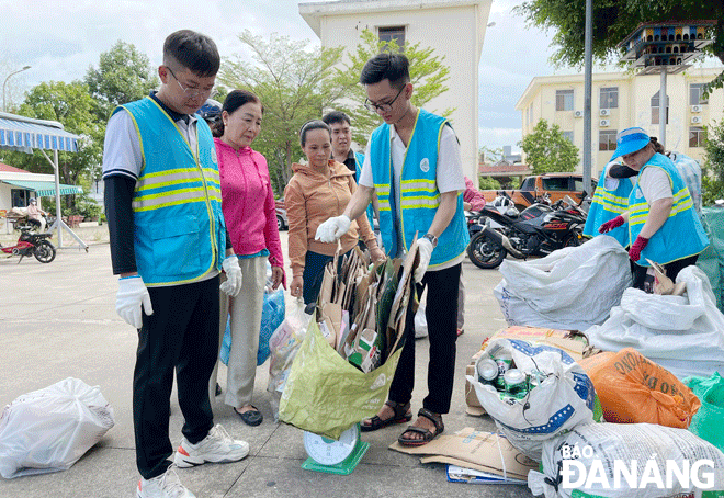 Việc triển khai ngày hội “Đổi rác lấy quà” góp phần nâng cao nhận thức trong việc phân loại rác tại nguồn. Trong ảnh: Nhân viên Chi nhánh Urenco miền Trung cân phế thải tài nguyên và trao quà cho người dân. Ảnh: TRỌNG HÙNG