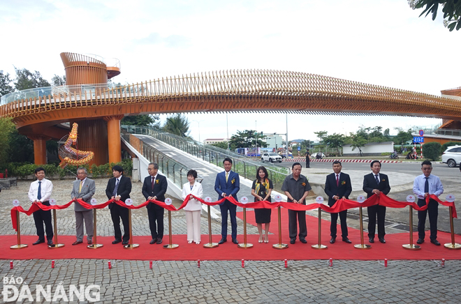 Lãnh đạo thành phố và đơn vị, cơ quan ngoại giao cắt băng khánh thành cầu đi bộ bắc qua đường Nguyễn Tất Thành ở phía trước Khách sạn Mikazuki. Ảnh: HOÀNG HIỆP