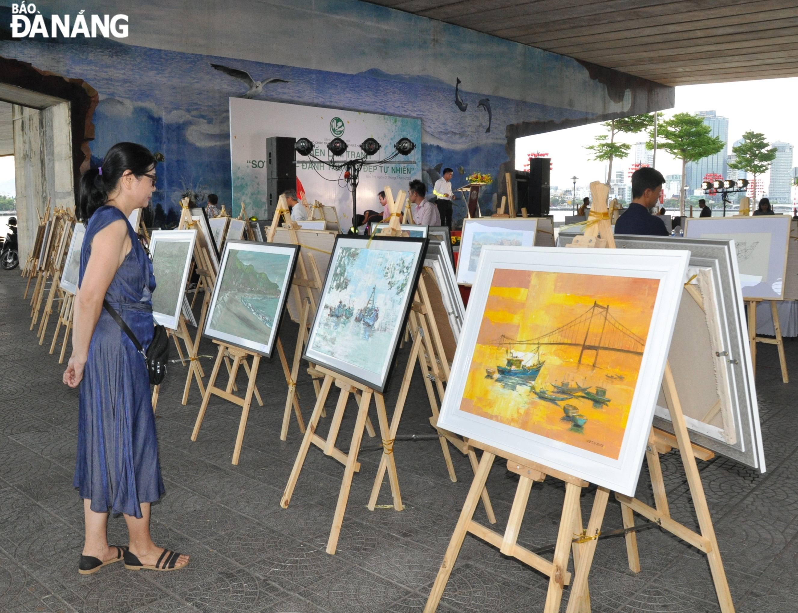 Visitors admiring the paintings at the exhibition. Photo: LE HUNG