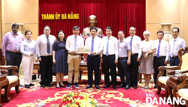 Da Nang Party Committee Deputy Secretary cum municipal People's Council Chairman Luong Nguyen Minh Triet (7th, right) presenting a souvenir to CEO Jimmy Toh Yong Leng (5th, left). Photo: T.PHUONG