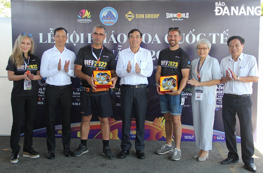 Chairman of the Da Nang People's Committee Le Trung Chinh (center) presenting gifts to representatives of the two teams that will perform in the final night.