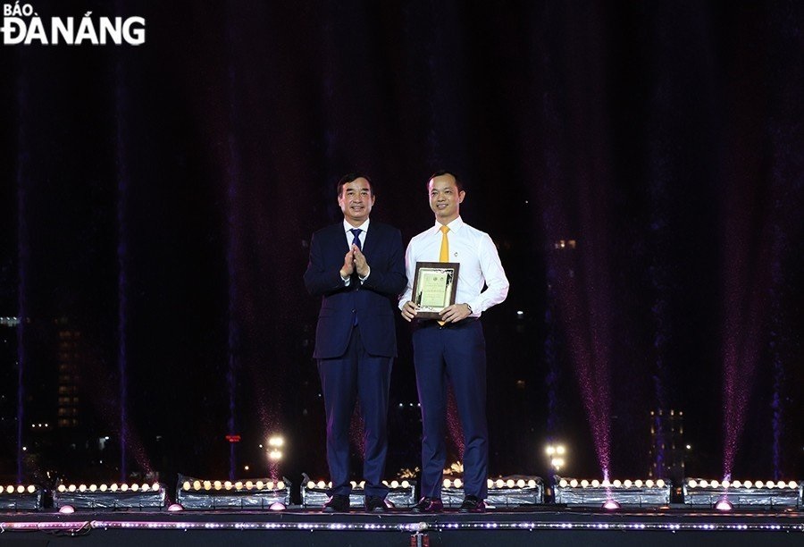 Municipal People's Committee Chairman Le Trung Chinh (left) presenting the sponsorship certificate to Sun Group representative.