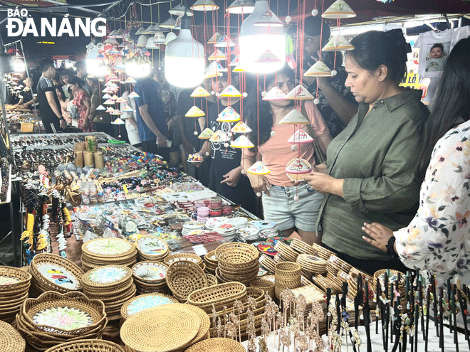 Foreign tourists are interested in the city’s souvenir items that symbolize local cultural elements. Photo: D.N