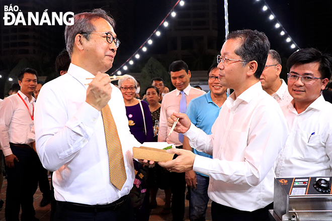 Party Committee Secretary Nguyen Van Quang (right) and Japanese Ambassador to Viet Nam Yamada Takio visit booths at the Viet Nam - Japan Festival in 2023, July, 13, 2023. Photo: X.D