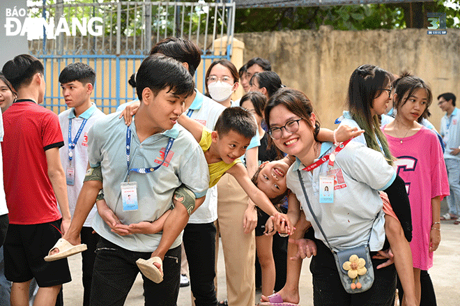 Thành viên nhóm Hand In Hand cùng các em nhỏ tại Trung tâm Bảo trợ trẻ em đường phố Đà Nẵng trong chương trình “Nụ cười nắng hạ”. Ảnh: HIH3T