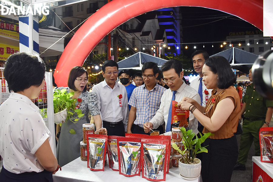 Representatives of leaders of departments, agencies, branches, districts and wards visit a OCOP booth. Photo: THU HA