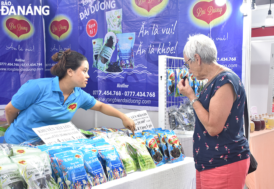 An international visitor trying out products on display at local stalls. Photo: T.HA