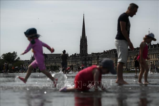 Người dân giải nhiệt tránh nóng tại khu vực đài phun nước ở Bordeaux, Pháp. Ảnh tư liệu: AFP/TTXVN