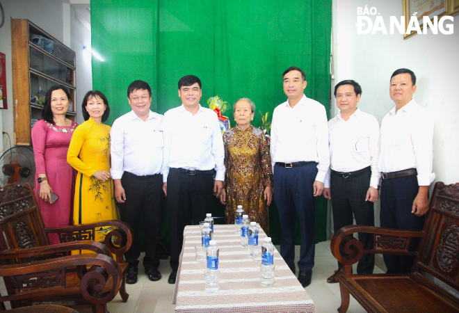 Chủ tịch UBND thành phố Lê Trung Chinh (thứ 3, bên phải sang) tặng quà Bà mẹ Việt Nam anh hùng Phan Thị Tùng (thứ 5, bên trái sang). Ảnh: N.Q