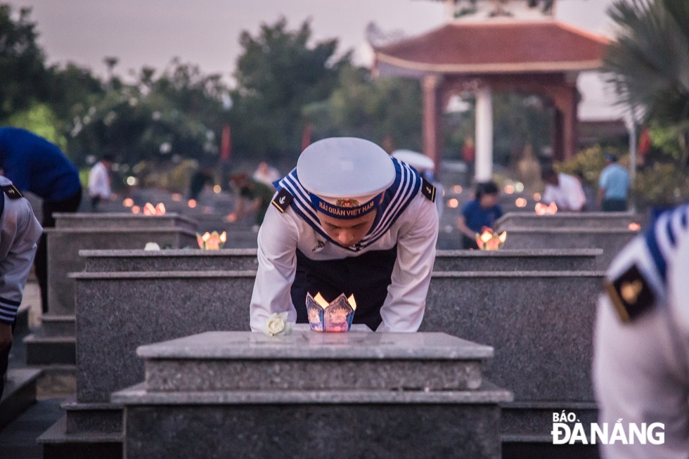 A young navy soldier offers incense to commemorate heroes and martyrs at the Martyrs Cemetery in Hoa Khuong Commune.