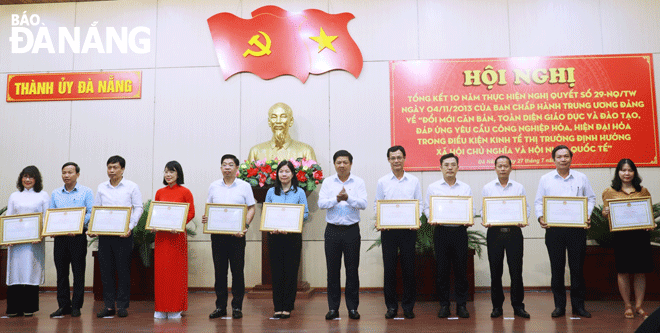 Phó Bí thư Thường trực Thành ủy, Chủ tịch HĐND thành phố Lương Nguyễn Minh Triết (thứ 6, bên phải sang) trao bằng khen cho các tập thể đạt thành tích xuất sắc trong thực hiện Nghị quyết 29-NQ/TW. Ảnh: N.H