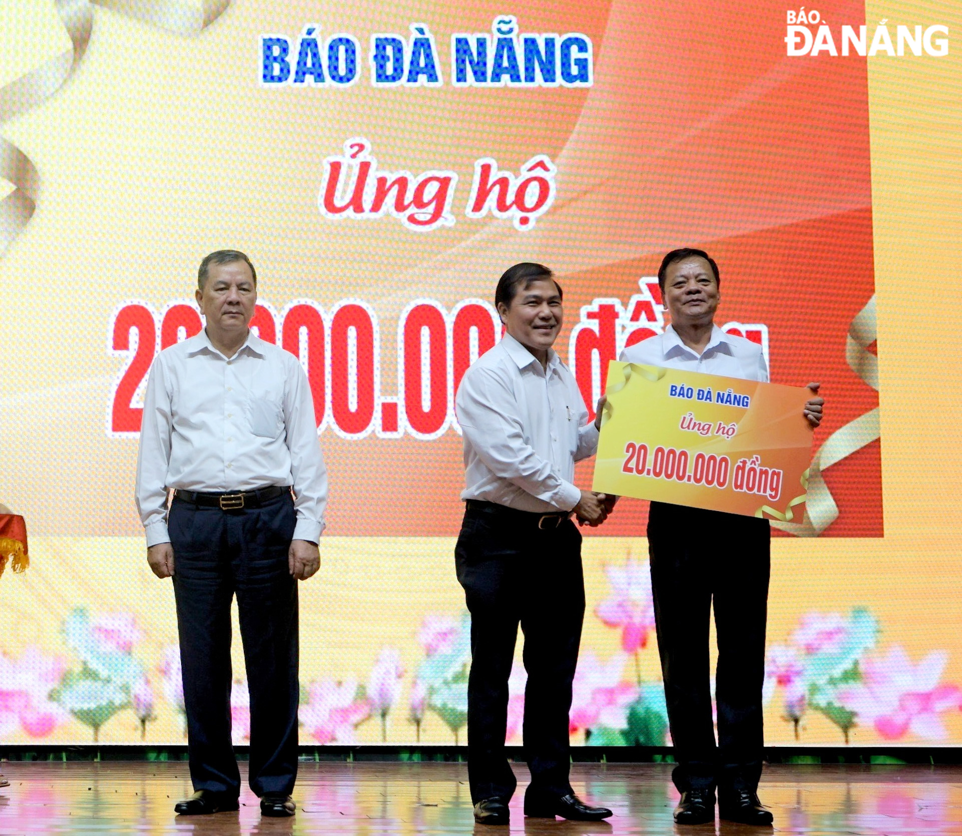 Editor-in-Chief of the Da Nang Newspaper Nguyen Duc Nam (middle) presents the programme's organisers with an amount of VND 20 million in support of AO victims in the city. Photo: LE HUNG