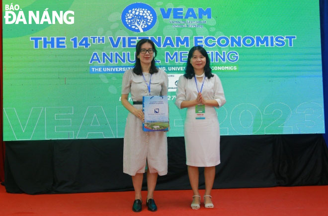 A representative of the event’s organizers presenting a souvenir gift to sponsors, including the Vietnam Initiative for Energy Transition (VIET) and the World Bank. Photo: NGOC HA