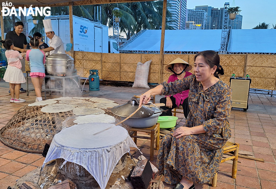 A tourist experiencing how to make Tuy Loan rice paper. Photo: THU HA