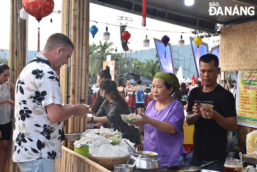 Foreign tourists enjoy the food. Photo: THU HA