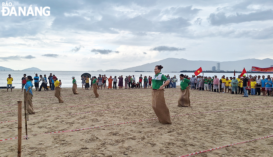Các hội viên hội nông dân của 3 quận tham gia nhảy bao bố tiếp sức trên cát.