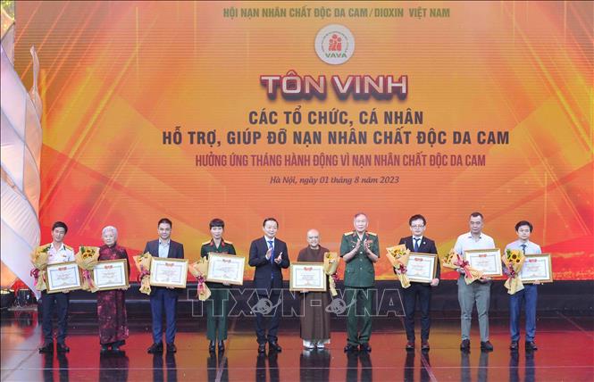 Phó Thủ tướng Trần Hồng Hà, Thượng tướng Nguyễn Văn Rinh - Chủ tịch hội Nạn nhân chất độc da cam/dioxin Việt Nam - trao Bằng tri ân tấm lòng vàng vì nạn nhân chất độc da cam cho các tập thể và nhà hảo tâm. Ảnh: TTXVN