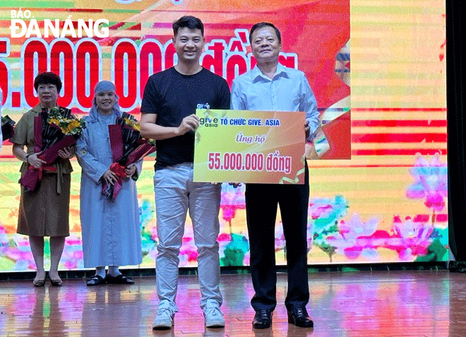 Anh Vũ Xuân Thành (bên trái) trao tặng 55 triệu đồng ủng hộ Trung tâm Bảo trợ nạn nhân chất độc da cam và trẻ em bất hạnh thành phố Đà Nẵng. Ảnh: LÊ HÙNG