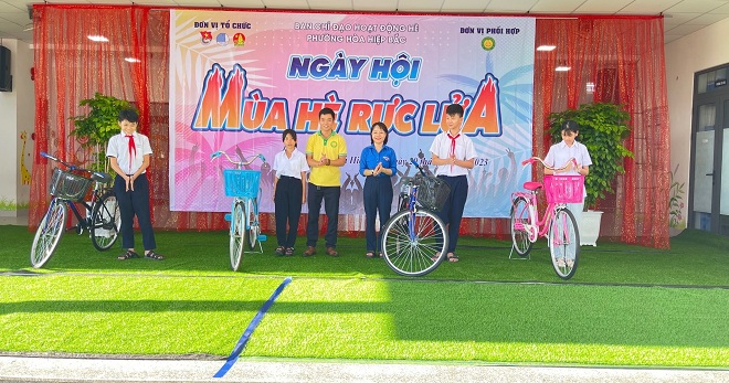 A representative of Youth Union Organisation of Hoa Hiep Bac Ward presenting bicycles to 4 local poor pupils. Photo: KHANH HUYEN