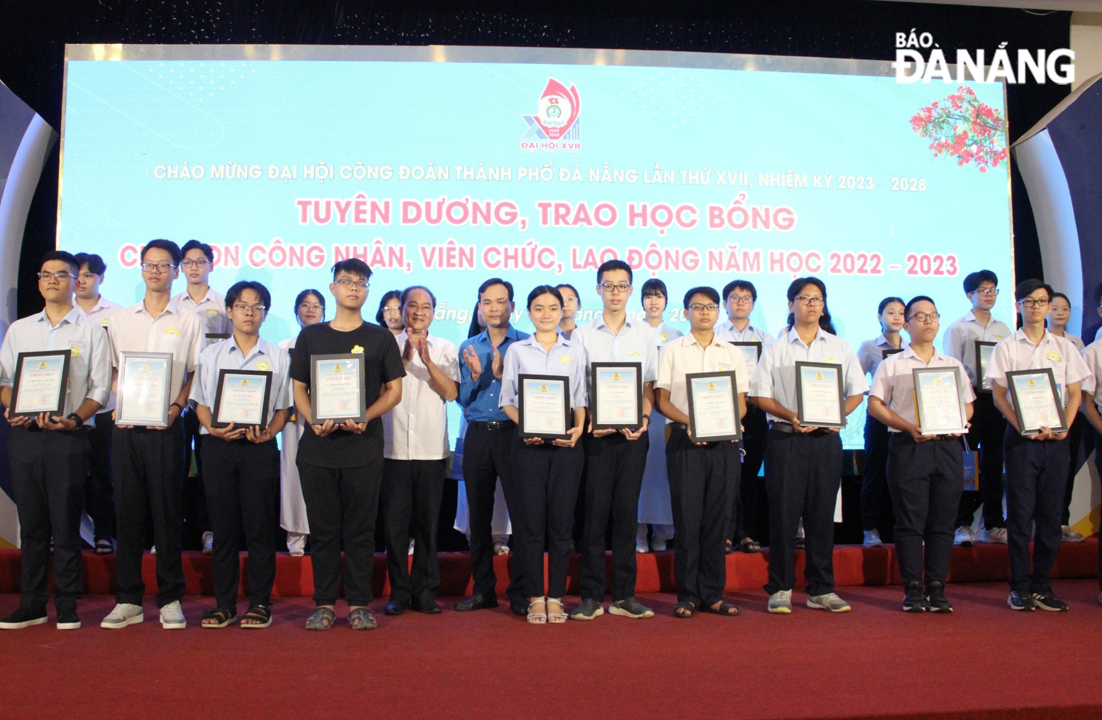 Vice Chairman of the Viet Nam Fatherland Front Committee in Da Nang Duong Dinh Lieu (5th, left) and Chairman of the municipal Confederation of Labour Nguyen Duy Minh (6th, left) present gifts to children who achieved high academic results. Photo: X.HAU